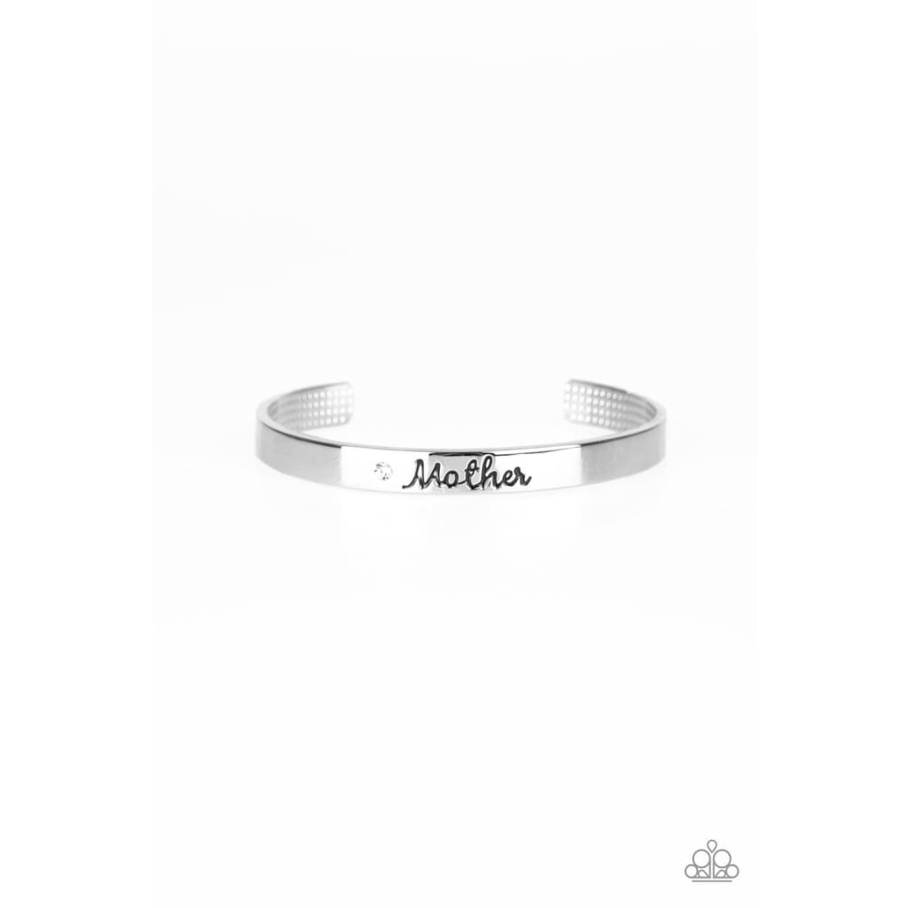 Paparazzi Every Day Is Mothers Day - Mom Bracelet Silver A sleek silver cuff wraps around the wrist in a casual fashion. Dotted with a dainty white rhinestone, the shimmery cuff is engraved in the word “Mother” for a loving finish. Sold as one individual cuff bracelet.