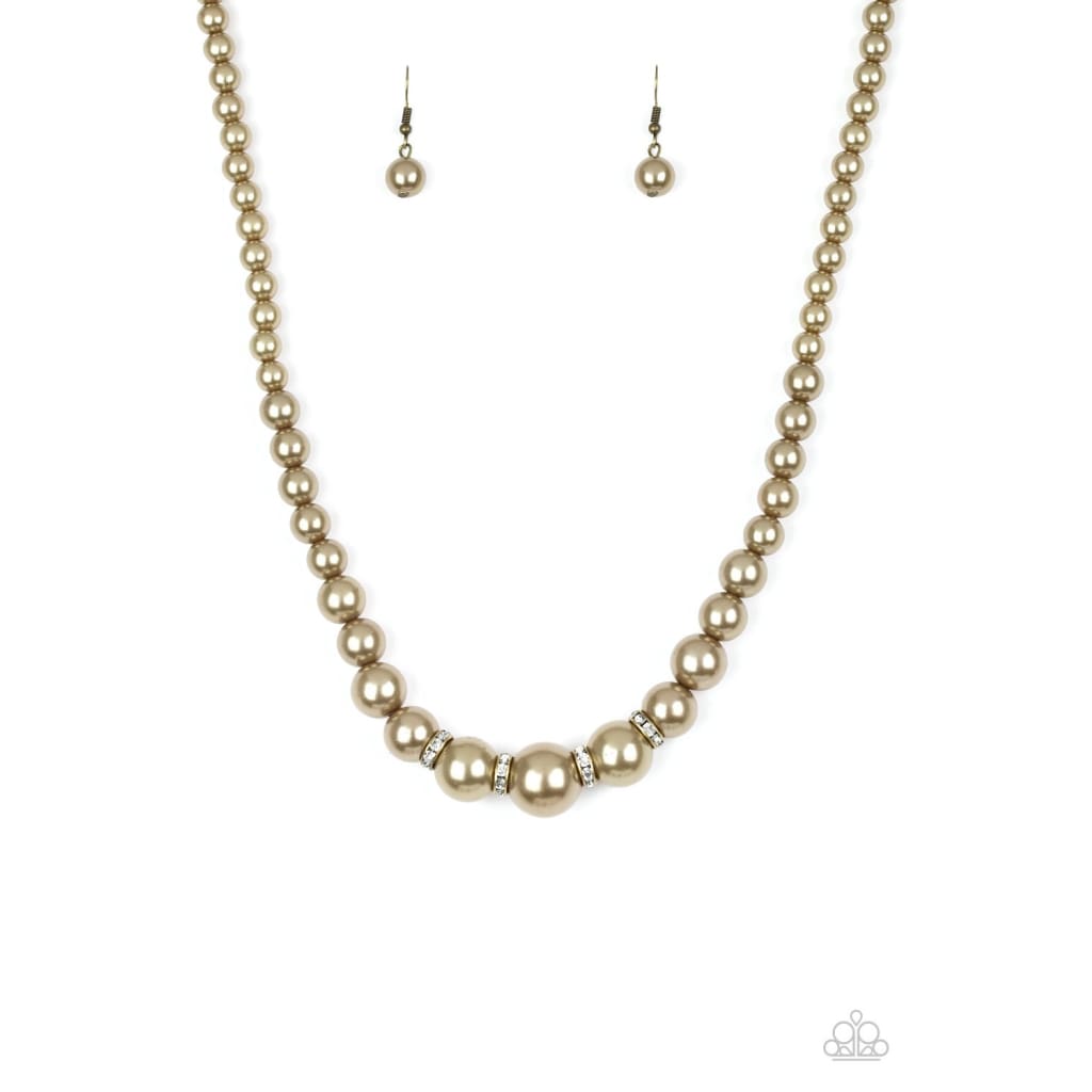 Paparazzi Party Pearls - Brass Necklace Pearly brass beads trickle below the collar for a classic look. Dazzling white rhinestones, glittery rings are sprinkled between the pearly beads for a timeless finish. Sold as one individual brass necklace. Includes one pair of matching earrings. 
